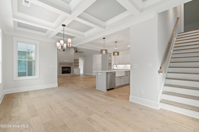 unfurnished living room featuring a fireplace, beamed ceiling, coffered ceiling, and light hardwood / wood-style floors