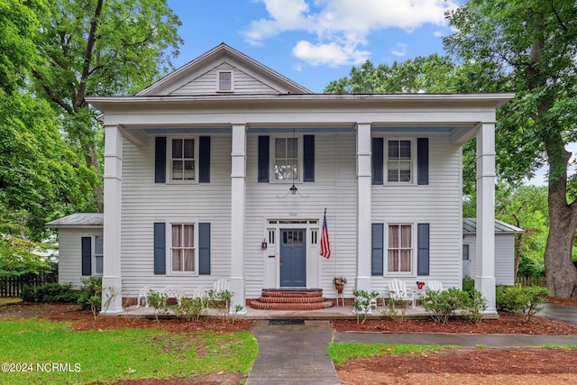 neoclassical home featuring covered porch