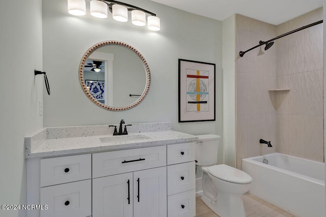 full bathroom with vanity, tiled shower / bath, ceiling fan, and toilet