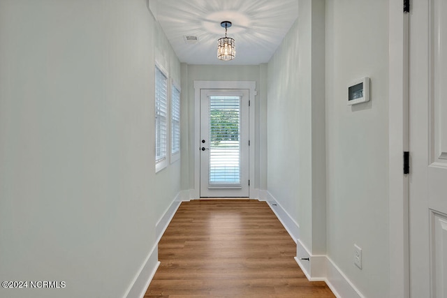 doorway featuring hardwood / wood-style flooring and a chandelier