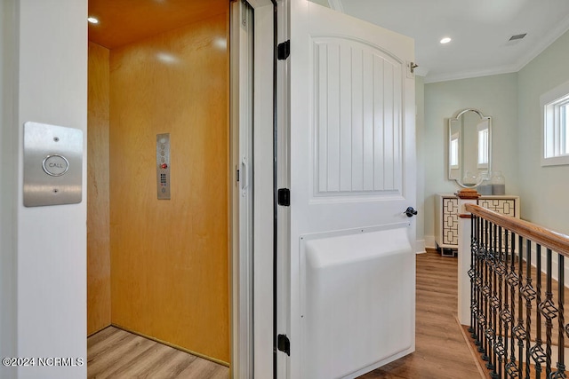 hall featuring ornamental molding and light hardwood / wood-style flooring