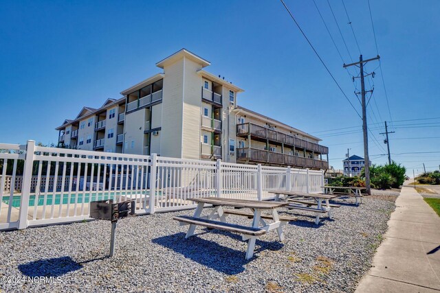 view of property featuring a community pool and fence