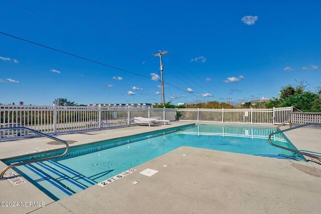 community pool featuring a patio and fence