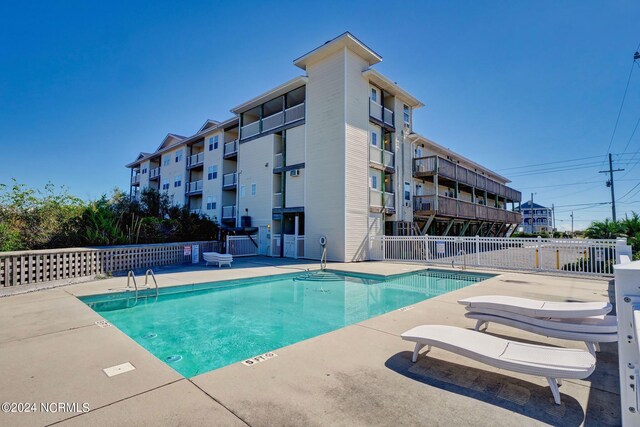 community pool featuring a patio area and fence