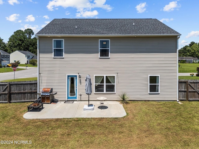 rear view of house with a patio and a lawn