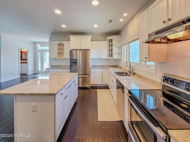 kitchen featuring appliances with stainless steel finishes, white cabinetry, tasteful backsplash, and sink