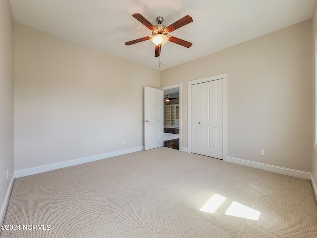 unfurnished bedroom featuring carpet floors, ceiling fan, and a closet