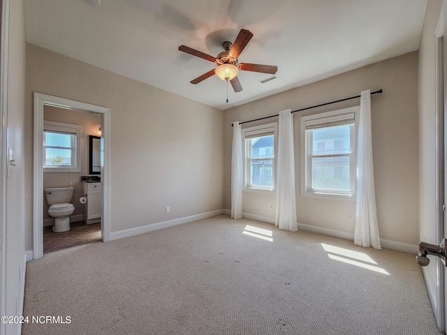 unfurnished bedroom featuring ceiling fan, connected bathroom, and light colored carpet