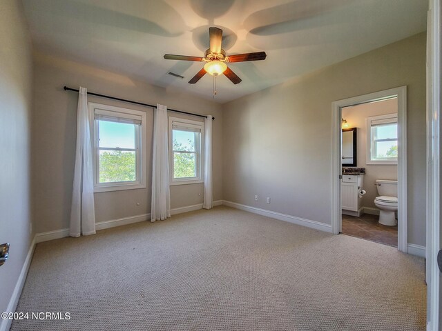 unfurnished bedroom featuring ensuite bath, ceiling fan, and carpet flooring