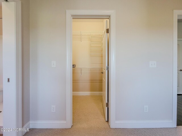 hallway featuring light colored carpet