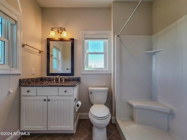 bathroom with tile patterned floors, vanity, a shower, and toilet