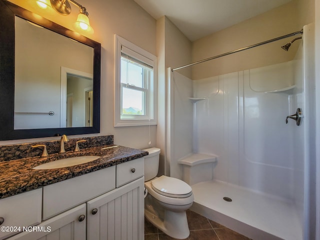 bathroom with tile patterned floors, vanity, walk in shower, and toilet