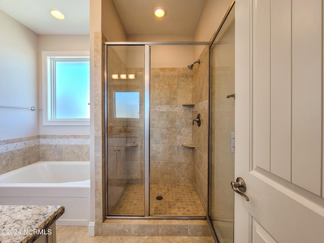 bathroom featuring vanity, independent shower and bath, and tile patterned floors