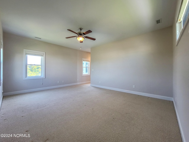 carpeted spare room with ceiling fan and a healthy amount of sunlight