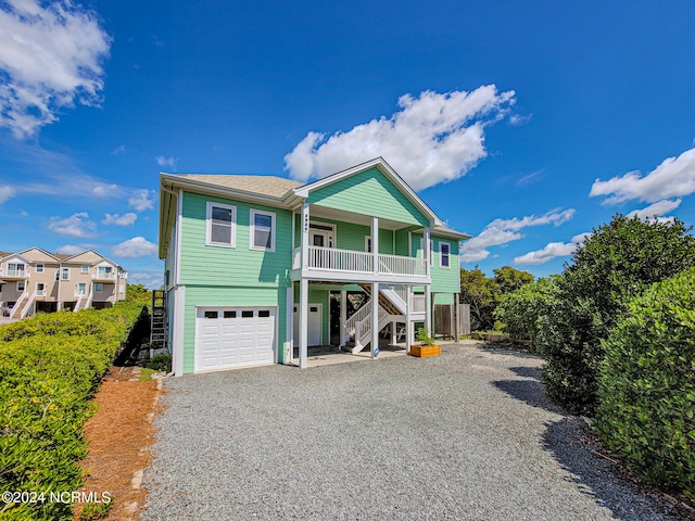 coastal inspired home with a garage and covered porch