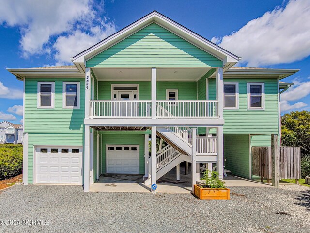 raised beach house with a porch and a garage