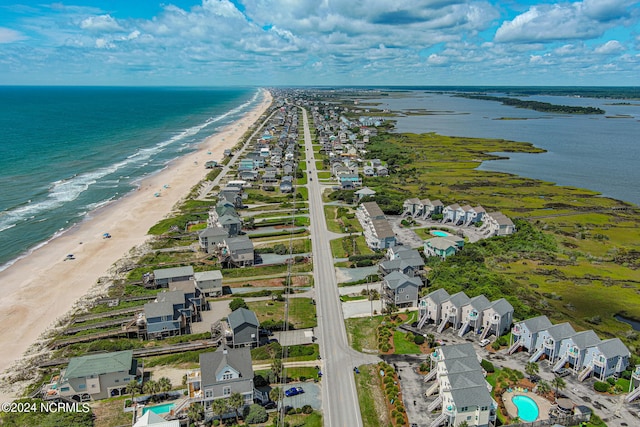 birds eye view of property featuring a water view and a beach view