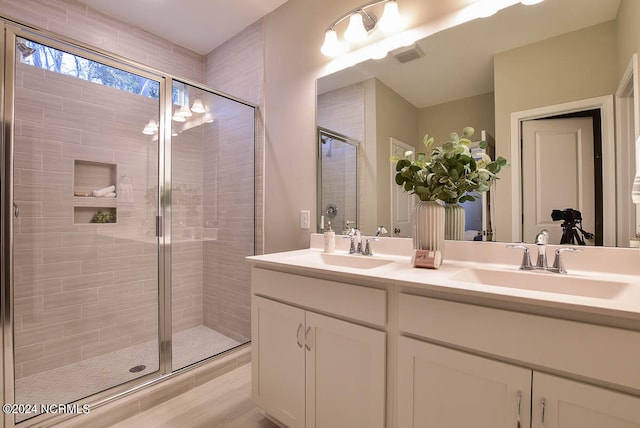 bathroom featuring hardwood / wood-style floors, walk in shower, and vanity