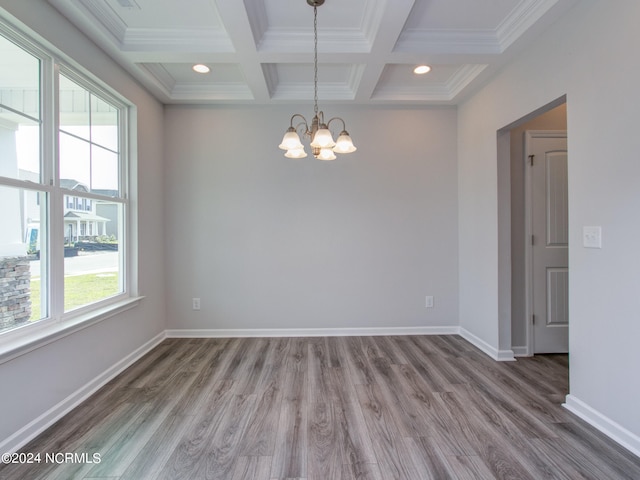 spare room featuring wood-type flooring, a notable chandelier, and a wealth of natural light