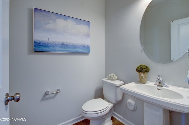 bathroom featuring wood-type flooring and toilet