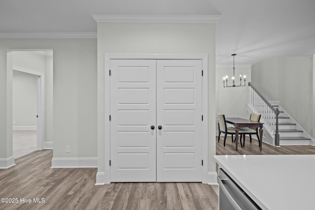 interior space with crown molding, wood finished floors, baseboards, and a chandelier