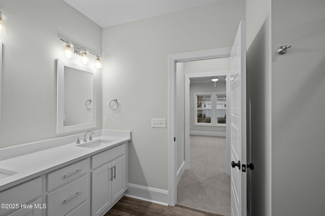 bathroom featuring a sink, baseboards, and double vanity