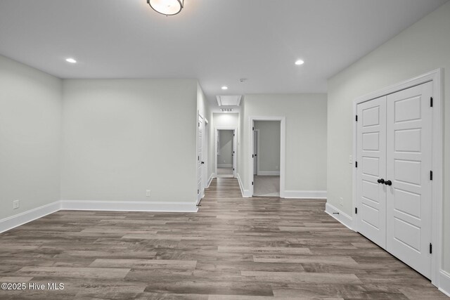 interior space with recessed lighting, attic access, baseboards, and wood finished floors