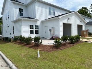 rear view of property featuring a lawn and a patio area