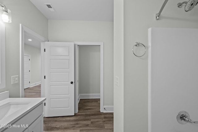 full bathroom featuring visible vents, vanity, baseboards, and wood finished floors