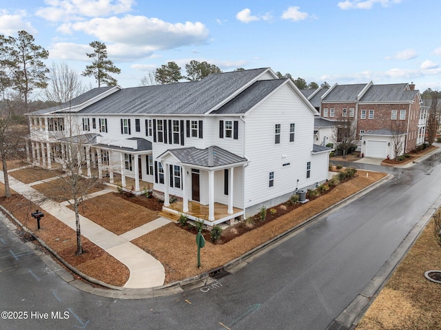 multi unit property with covered porch and a shingled roof