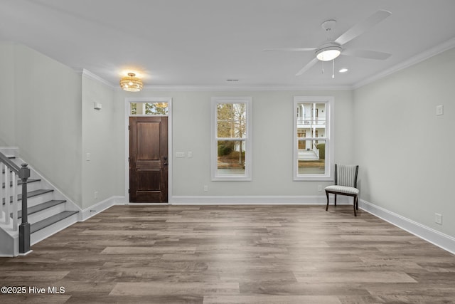 entrance foyer with crown molding, baseboards, stairway, wood finished floors, and a ceiling fan