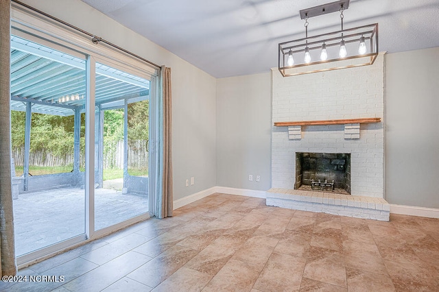 unfurnished living room featuring a fireplace, brick wall, tile patterned flooring, and a textured ceiling