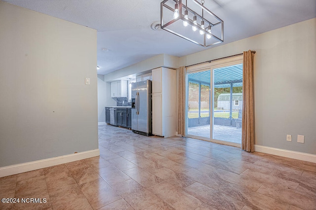 unfurnished living room featuring a notable chandelier and light tile patterned floors