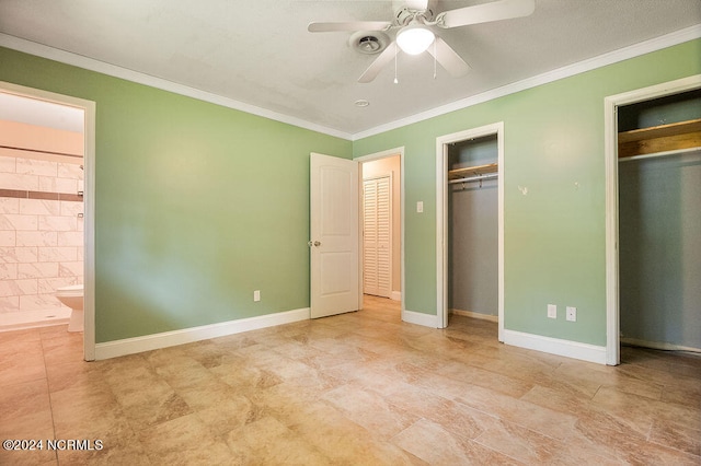 unfurnished bedroom with ensuite bath, tile patterned floors, two closets, ceiling fan, and ornamental molding