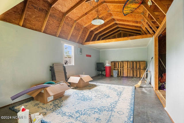 misc room with vaulted ceiling and concrete flooring