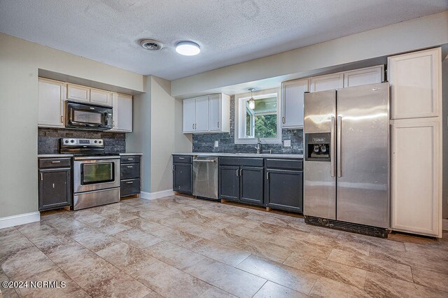 kitchen featuring tasteful backsplash, light tile patterned floors, gray cabinets, stainless steel appliances, and sink