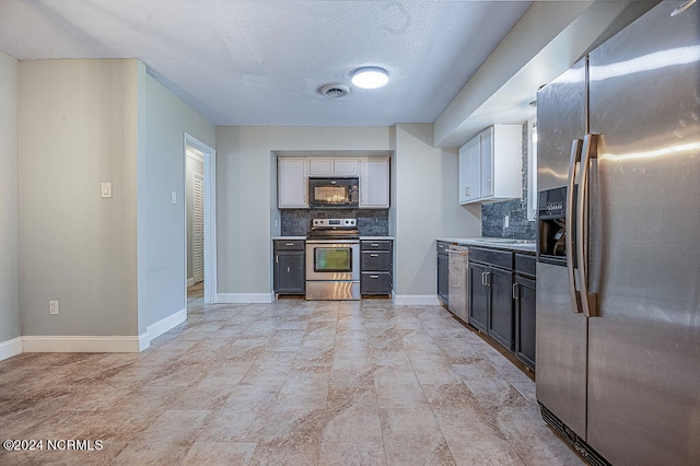 kitchen with decorative backsplash, appliances with stainless steel finishes, and light tile patterned floors