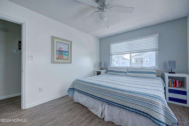 bedroom with wood-type flooring, a textured ceiling, and ceiling fan