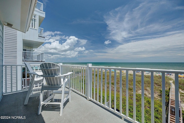 balcony with a water view and a view of the beach