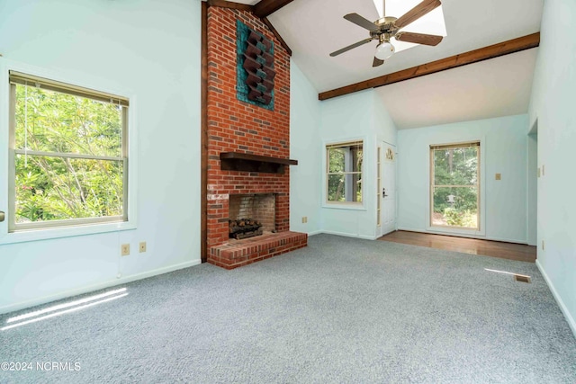 unfurnished living room with ceiling fan, beam ceiling, high vaulted ceiling, carpet floors, and a fireplace