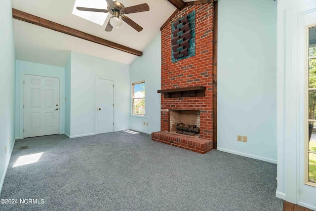 unfurnished living room featuring beam ceiling, carpet floors, and a brick fireplace