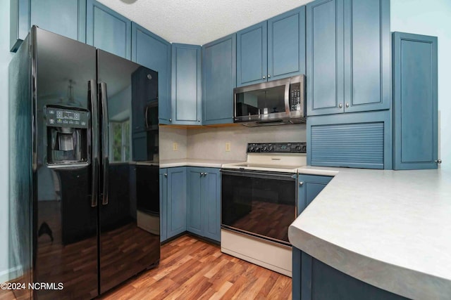 kitchen featuring range with electric stovetop, blue cabinets, light hardwood / wood-style floors, a textured ceiling, and black refrigerator with ice dispenser