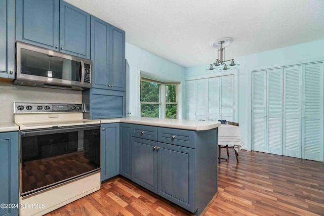 kitchen featuring blue cabinets, pendant lighting, kitchen peninsula, and electric stove