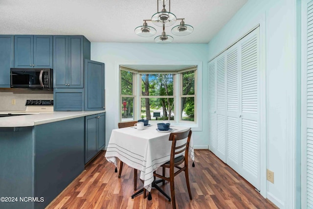 dining area with dark hardwood / wood-style floors and a textured ceiling