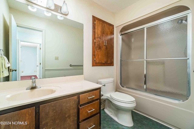 full bathroom with enclosed tub / shower combo, vanity, and toilet