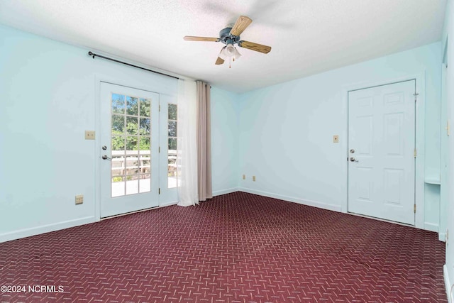 carpeted spare room with ceiling fan and a textured ceiling