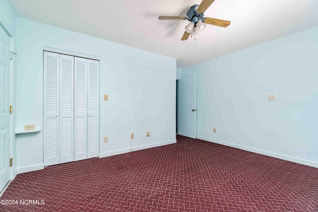 unfurnished bedroom featuring ceiling fan, a closet, and dark colored carpet