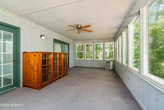 unfurnished sunroom with a wall mounted air conditioner and ceiling fan