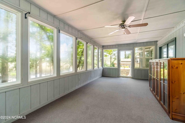 unfurnished sunroom featuring ceiling fan