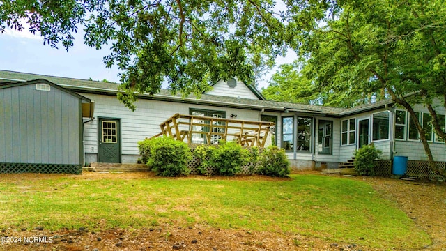 back of house with a yard, a sunroom, and a deck